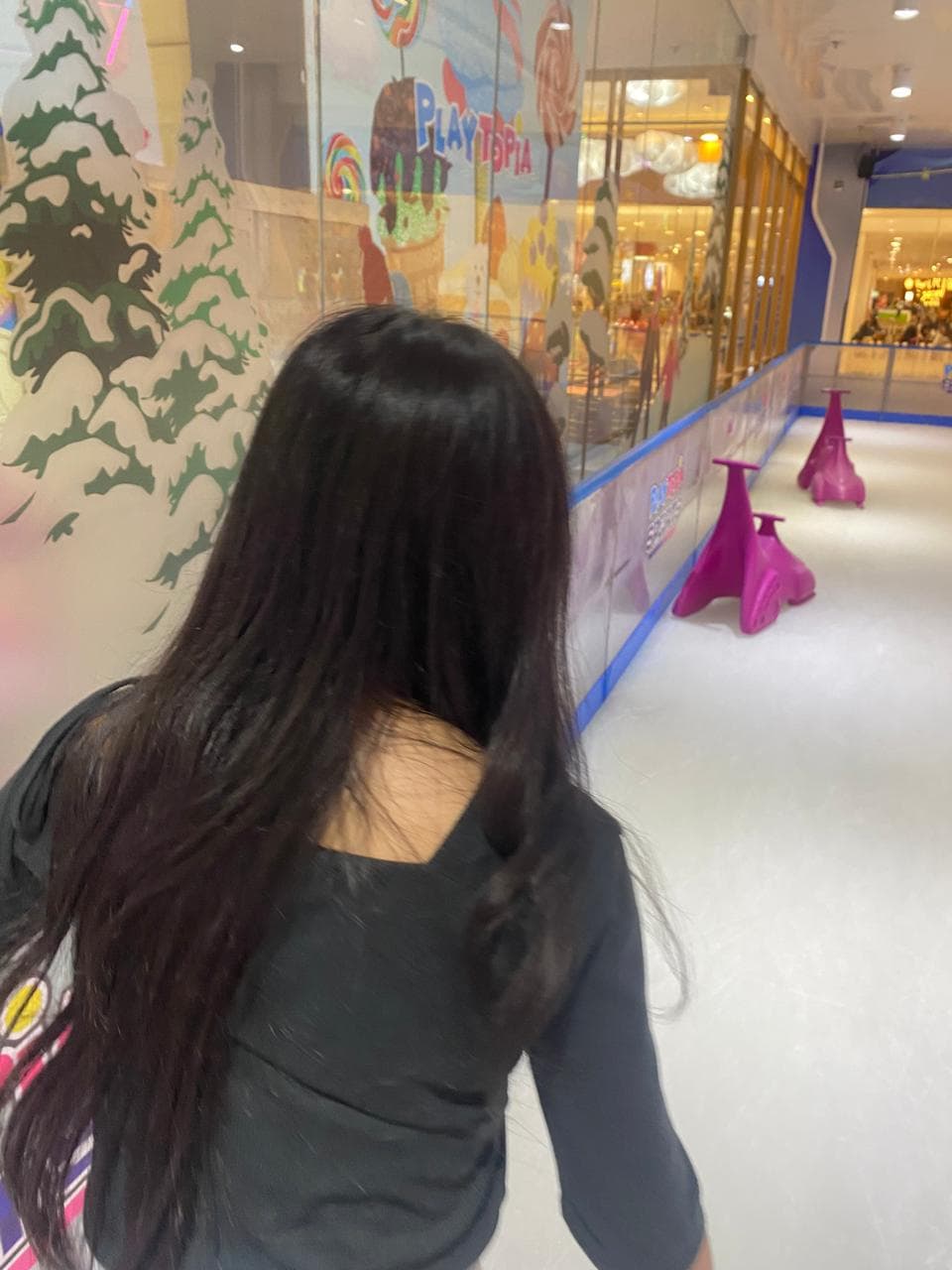 Foto candid Nayla berjalan di dekat area permainan indoor.