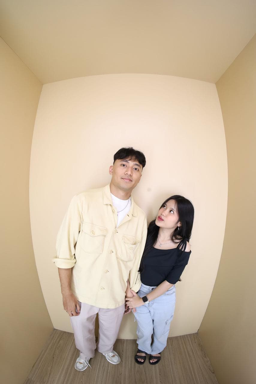 Nayla menatap pasangannya saat mereka berpose di ruang krem.