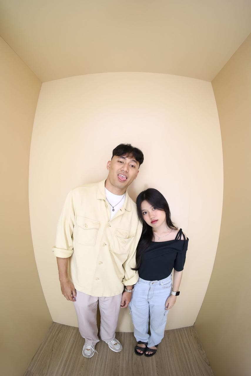Nayla dan pasangannya berdiri tegak dan tersenyum untuk foto penutup di ruang krem.